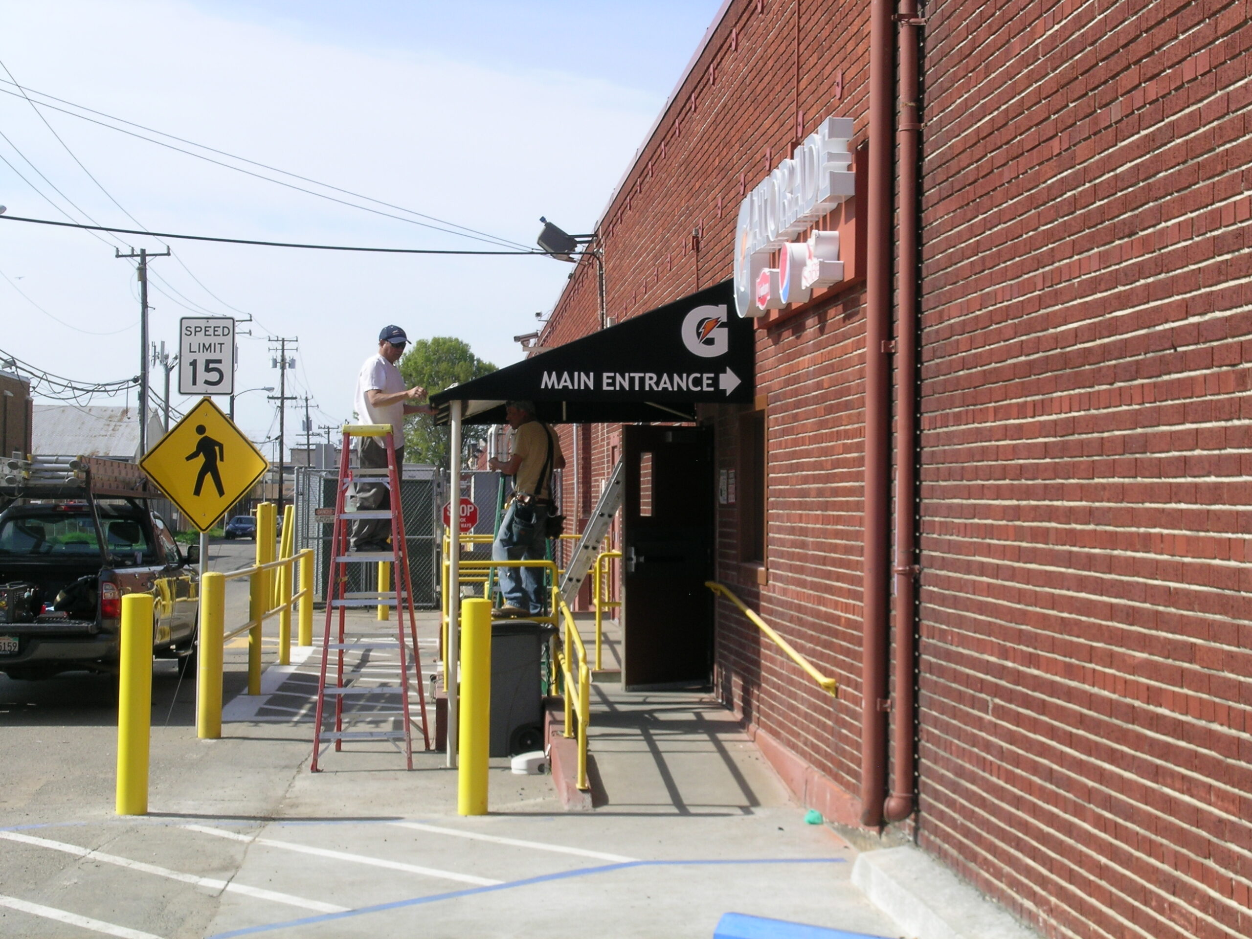 Workers preparing main entrance signage.